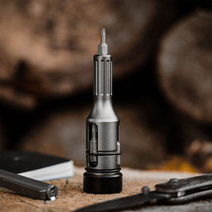 Bit Driver Grande bit driver tool standing upright next to driver bits on wood surface
