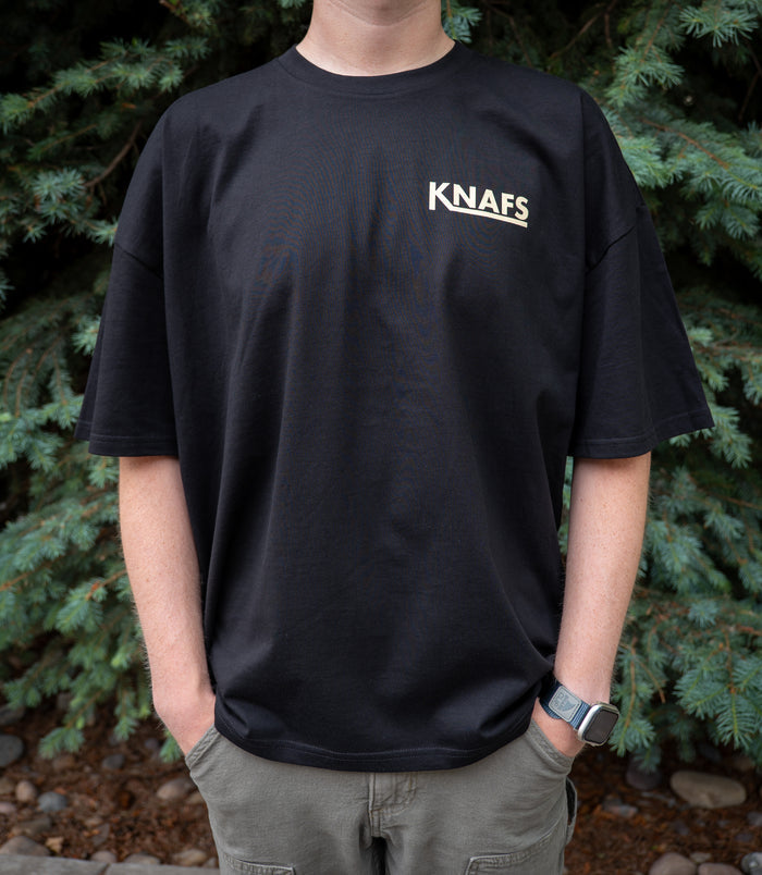 Man wearing black Knafs Quality Knives and High Fives t-shirt, outdoors