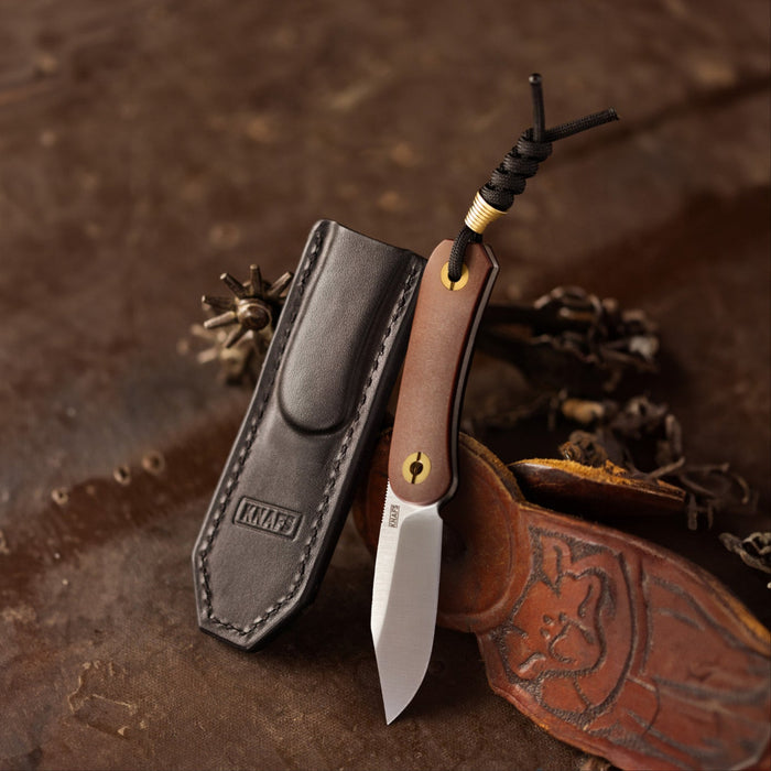 Lander 4 fixed blade knife with sheath, resting on leather background